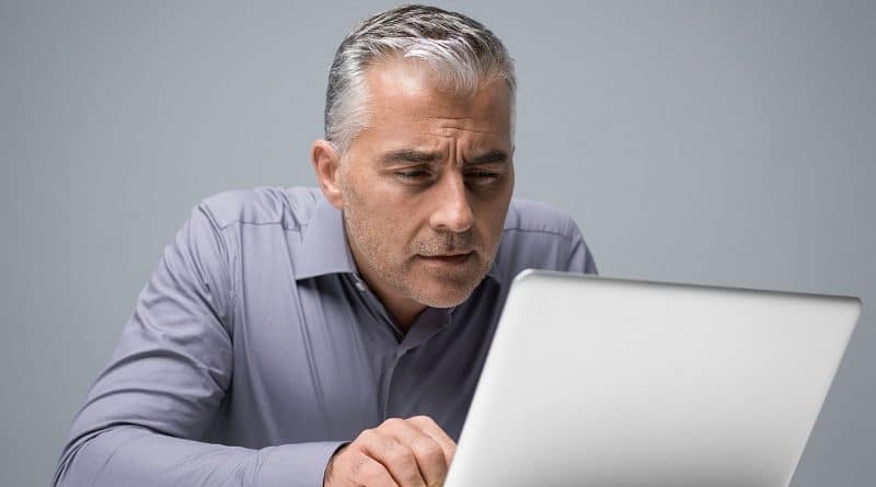adulto mayor enfrente de una computadora