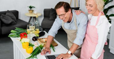 Pareja de adultos mayores en la cocina sonrientes