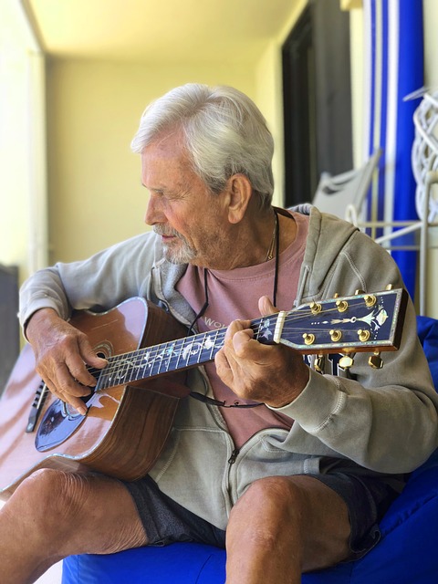 Adulto mayor tocando guitarra.